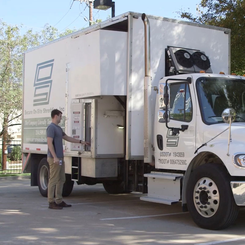 Employee operating a shredding truck